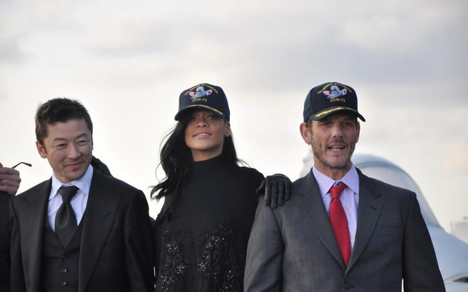 The cast and crew from the movie "Battleship" pose aboard the aircraft carrier USS George Washington following a press conference on the flight deck Monday. Pictured from left are Japanese actor Tadanobu Asano; pop singer Rihanna, who makes her acting debut in the film; and director Peter Berg.