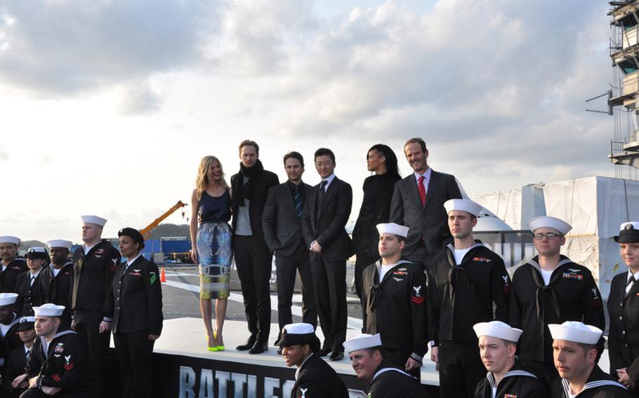 The cast and crew from the movie "Battleship" pose aboard the aircraft carrier USS George Washington following a press conference on the flight deck Monday. Pictured from left on stage are Brooklyn Decker, Alexander Skarsgard, Taylor Kitsch, Tadanobu Asano, Rihanna and director Peter Berg.