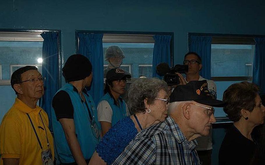 A North Korean soldier peers into the window of a conference room at the Joint Security Area of the Demilitarized Zone on May 23, 2012, as a group of U.S. Korean War veterans are briefed about the building.