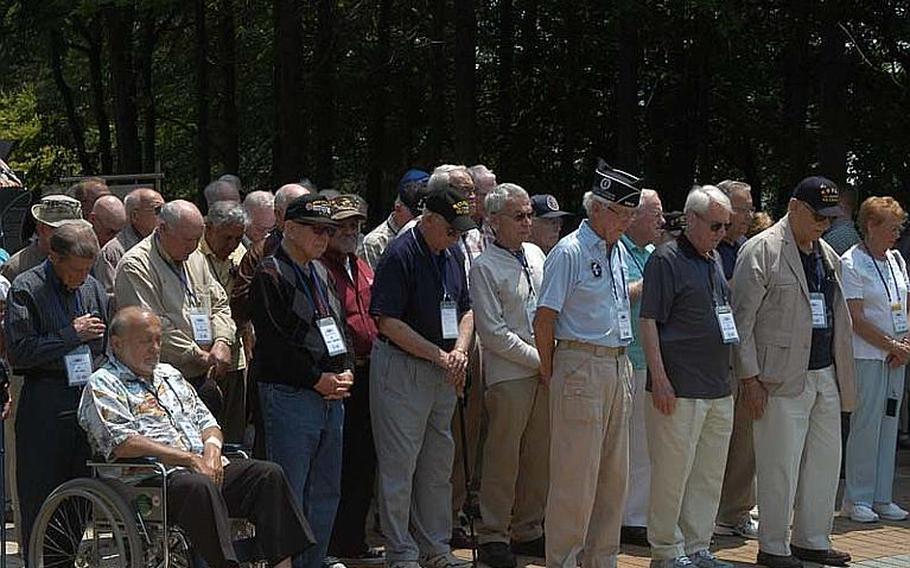 A group of U.S. Korean War veterans, accompanied by their families and South Korean schoolgirls, bow their heads during a moment of silence during a wreath-laying ceremony May 23, 2012, at a monument dedicated to American participation in the war. The group visited several places in and around the Demilitarized Zone.
                       
Jon Rabiroff/Stars and Stripes