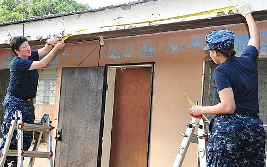 Petty Officers 2nd Class Anna Sterling, left, and Sasha Hutchinson take measurements during a Habitat for Humanity community relations project on Guam in January 2012. Sterling was killed July 23, 2012, when her motorcycle was struck by an allegedly intoxicated driver, who has been charged with murder.