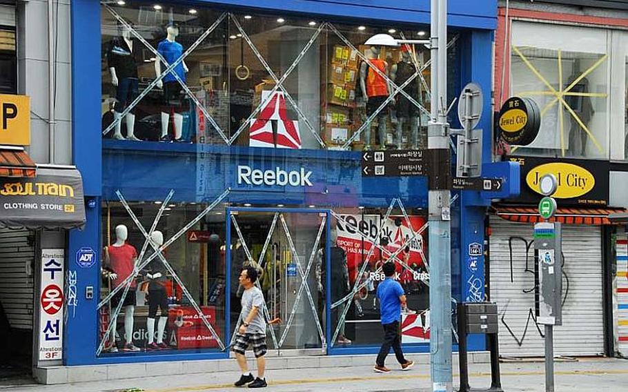 Pedestrians walk past one of many taped-up storefronts in Itaewon, the entertainment and shopping district outside U.S. Army Garrison Yongsan, on Aug. 28, 2012. Typhoon Bolaven was expected to reach Seoul later in the day after hitting Okinawa the day before, and forecasters had warned that the storm would be the strongest to affect the peninsula in years.