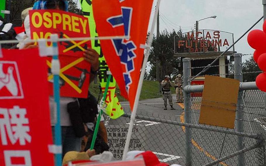 U.S. Marines stand guard at Futenma air station Oct. 1, 2012, as protesters gathered at an entrance gate for the fifth day of demonstrations against the deployment of Osprey aircraft.
