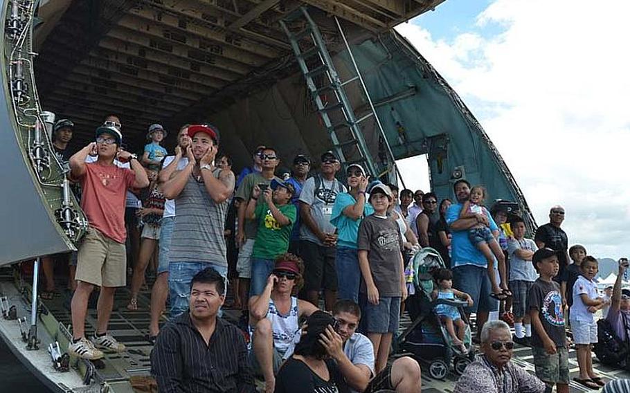 Spectators watch daredevil air maneuvers from the back of a display C-17 aircraft during the Kaneohe Bay Air Show on Sept. 30, 2012, at Marine Corps Base Hawaii. The event starred the Navy's Blue Angels, as well as a host of other aviators and parachutists.