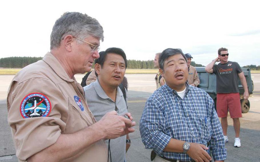 Retired Air Force pilot Jim Smolka shows two Yokota Air Base employees a photo of Mount Fuji from his personal digital camera on Oct. 8, 2012. Smolka is part of a NASA team that flew over northern Honshu on Oct. 8 to photograph volcanoes using a high-resolution radar imaging system known as UAVSAR. The data will be used by scientists to better predict volcanic activity.