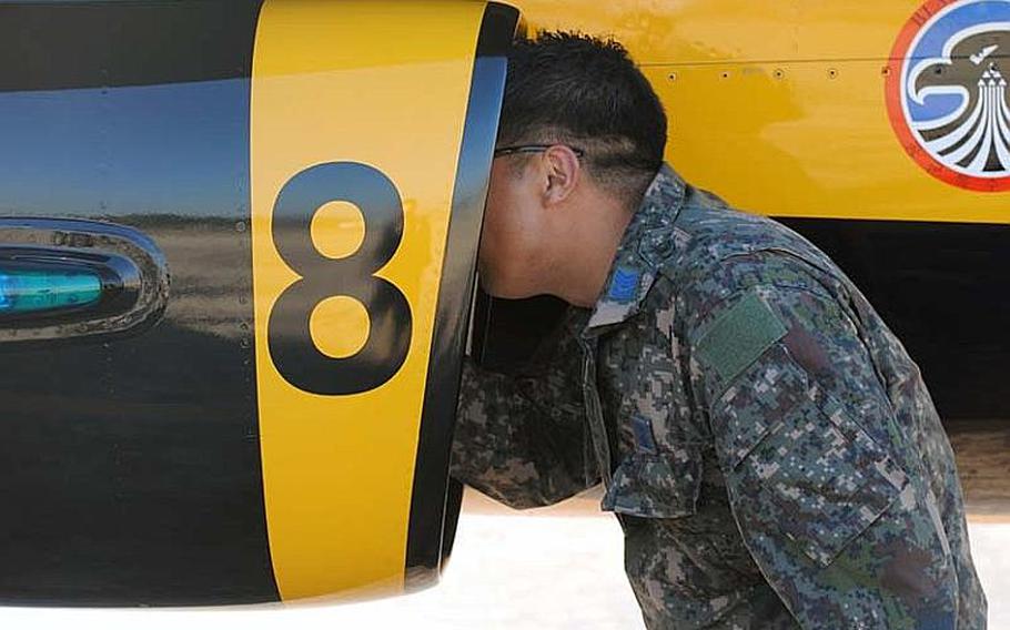 A maintenance crewmember of the Republic of Korea Air Force inspects an engine turbine by placing his head inside the air intake of a Black Eagles T-50B at Osan Air Base, South Korea on Oct. 18, 2012. The aerial demonstration team is expected to perform at this weekend&#39;s Osan Air Power Day 2012.