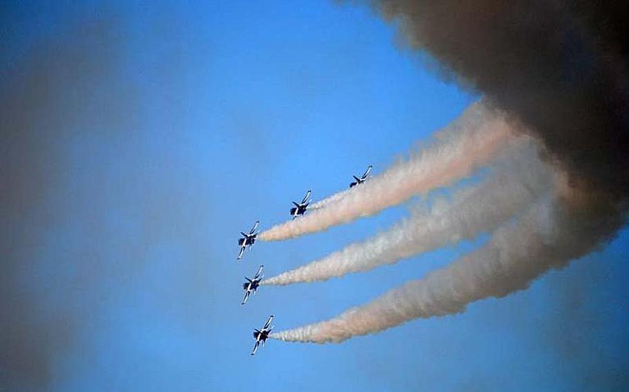 Five Black Eagles complete a sharp turn, with trailing white smoke, during a practice aerial demonstration at Osan Air Base, South Korea on Oct. 18, 2012.