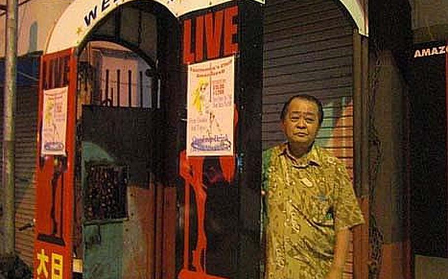 Tsutomu Arakaki, owner of Amazonesu, a club located on Gate 2 Street, outside Kadena Air Base, Okinawa, stands in front of his shuttered bar on Oct. 23, 2012. His bar has long catered to U.S. servicemembers, but because of the recently imposed curfew on troops, he recently put a sign, which reads &#39;&#39;Japanese heartily welcome&#39;&#39; as a desperate measure.