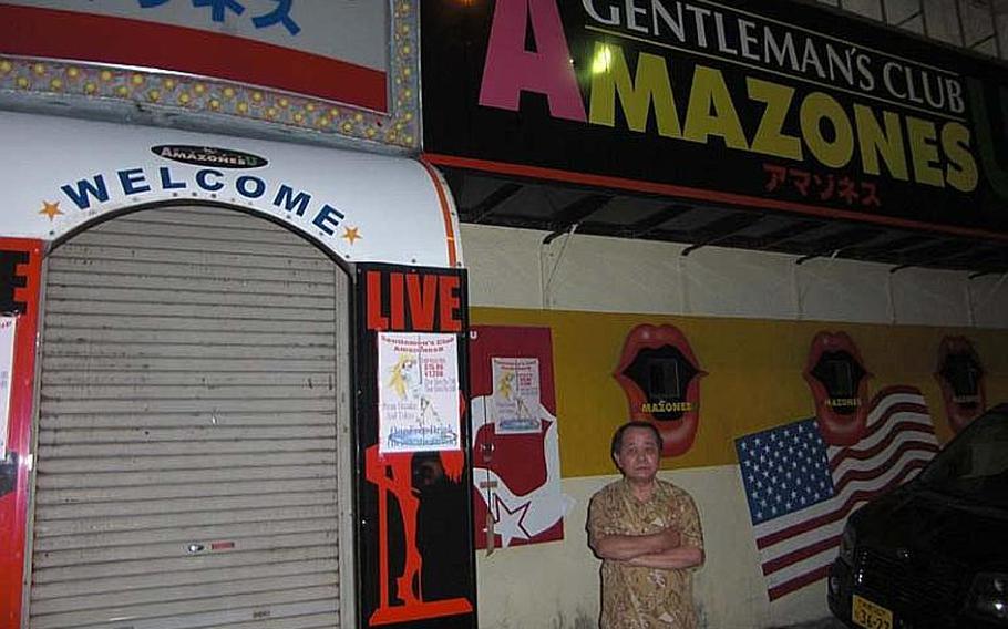 Tsutomu Arakaki, owner of Amazonesu, a club located on Gate 2 Street, outside Kadena Air Base, Okinawa, stands in front of his shuttered bar on Oct. 23, 2012. The recently imposed military curfew has completely stalled his business, he said. He has a bitter memory of 14 years ago, when a similar military curfew forced him to close his club for one full year.