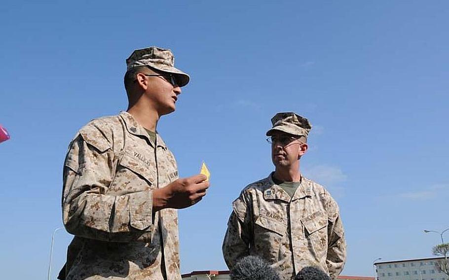 Sgt. Juan Vallejo, left, of Camp Foster, shows his gold Liberty Card to local media Oct. 25, 2012. "We take pride in everything we do," he told reporters. He was among about 1,000 Marines and sailors attended a brief given Thursday by Lt. Gen. Kenneth J. Glueck, commanding general of the III Marine Expeditionary Force and Marine Corps Bases Japan. The commanding general said that the Liberty Card Program that has been currently in effect for all military personnel on the island has contributed to ow crime rate involving servicemembers.