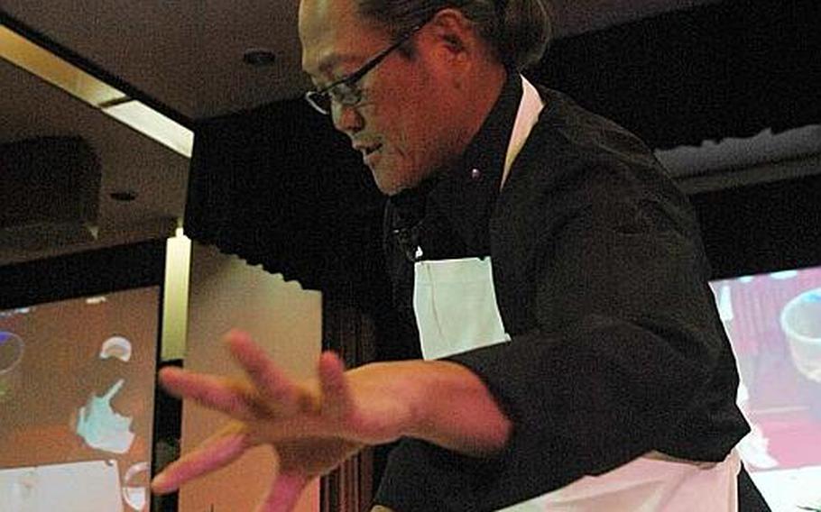 "Iron Chef" Masaharu Morimoto goes for a sprig of daikon radish during a cooking demonstration Nov. 4, 2012, at Yokota Air Base, Japan.