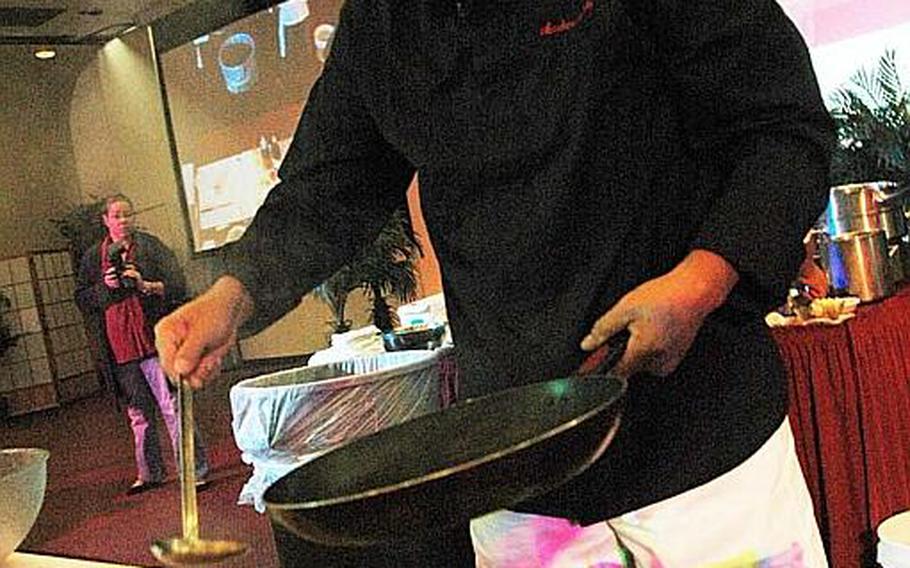 "Iron Chef" Masaharu Morimoto drizzles scorching hot sesame oil over thin strips of raw fish to before serving during a cooking demonstration Nov. 4, 2012, at Yokota Air Base, Japan.