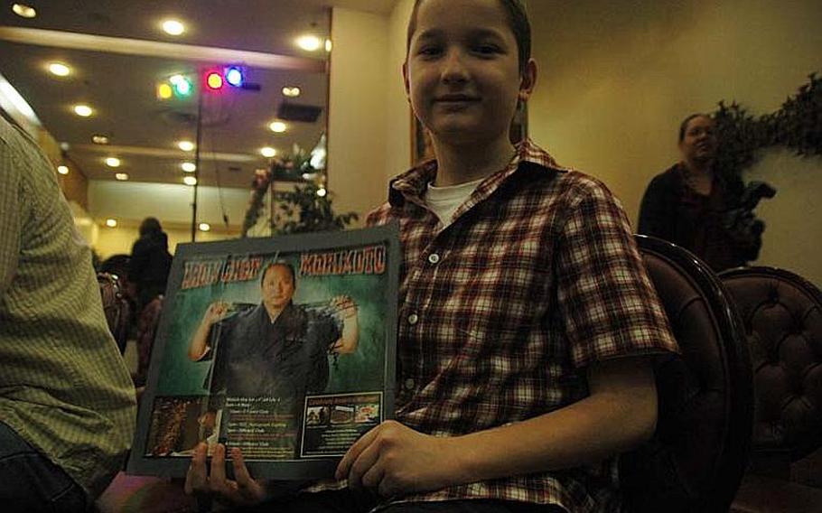 Joshua Rennekamp, a fourth-grader from Yokota Air Base, Japan, displays an autographed photo of "Iron Chef" Masaharu Morimoto after a demonstration Nov. 4, 2012, by the world-renowned chef.