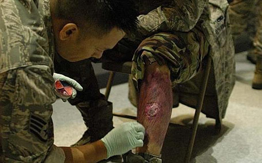 Staff Sgt. Don Flores applies moulage make-up to Airman 1st Class Benjamin Bell before a mock disaster exercise at Yokota Air Base, Japan, on Nov. 6, 2012. The U.S. military trains troops in the art of moulage, a French term for applying mock injuries for emergency response training.