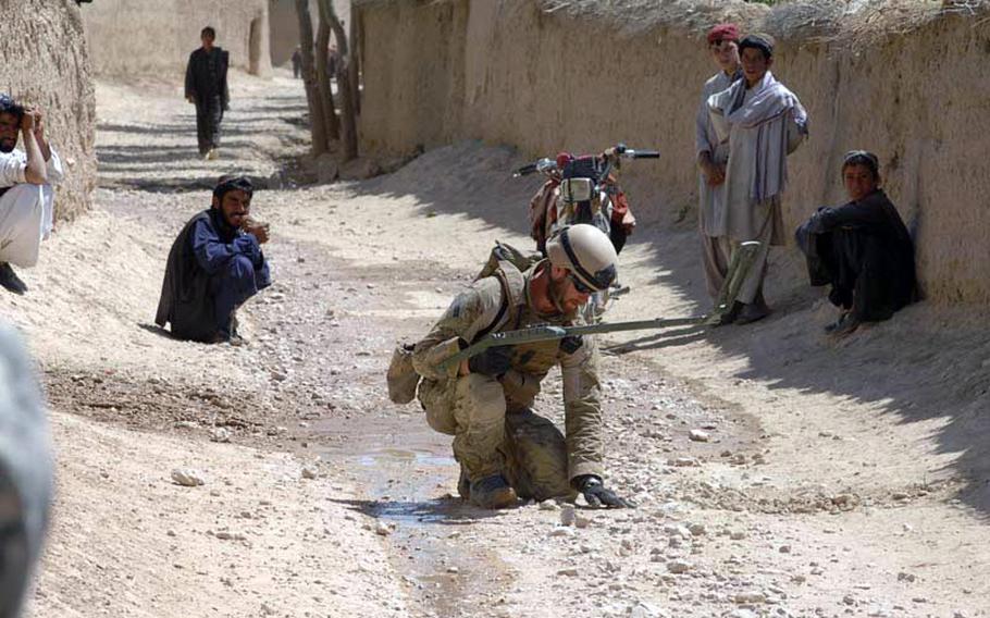 A Navy explosive ordnance disposal technician searches for a bomb in Zabul Province, Afghanistan in September 2010.