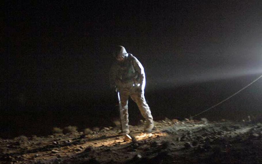 Air Force Tech Sgt. Jacob Monelo, 35, of Sacramento, Calif.,uses a metal detector to scan for booby traps while tracing the command wire of a bomb discovered in Kanahar Province, Afghanistan in August 2010. Officials predict that IED attacks with top 16,000 for 2012, the second straight year of reaching that figure.