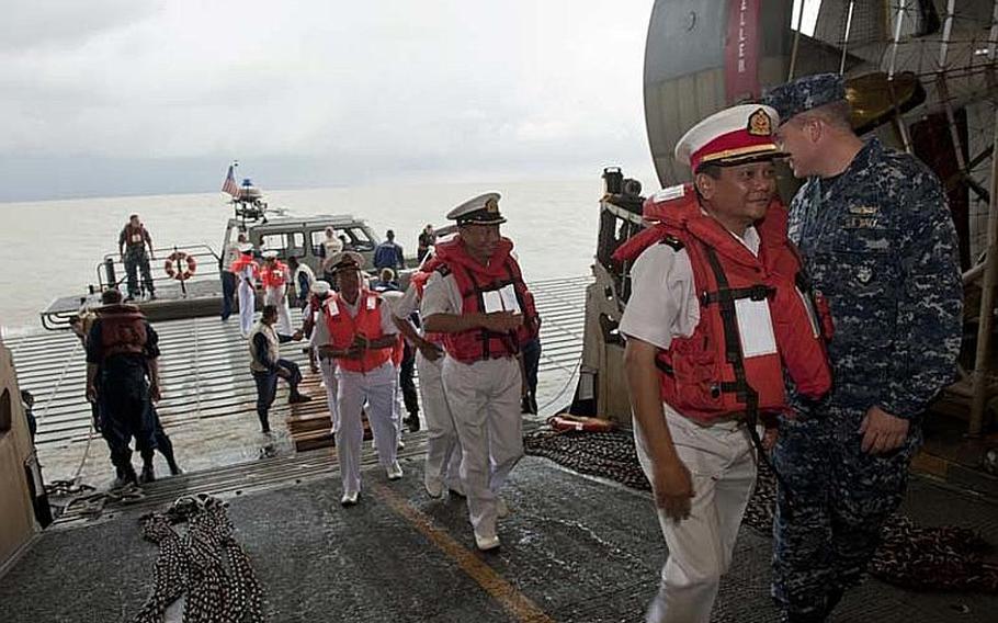 Myanmar naval officers arrive aboard the amphibious assault ship USS Bonhomme Richard in the Andaman Sea on Nov. 18, 2012, a day prior to President Barack Obama's speech in Yangon, Myanmar's commercial capital. Although sanctions prevent a large-scale relationship between the two militaries, the two countries are exploring academic and small-group exchanges.