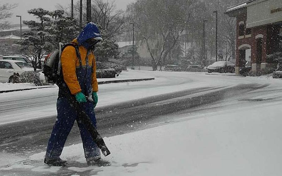 A worker clears snow outside the Dragon Hill Lodge at U.S. Army Garrison Yongsan early afternoon of Dec. 5, 2012. The first major snowfall of the season led to snarled traffic and closed schools at the Seoul base.