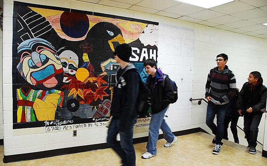Students at Seoul American High School walk past a mural that  may soon be replaced with a newer mural. That possibility has prompted an outcry from students and alumni who say it is a unifying symbol for past and current students.