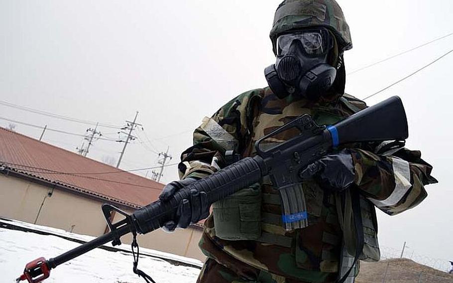 Staff Sgt. Beniteau Fenelus walks on patrol with his M-16 around Osan Air Base, South Korea, during the Beverly Midnight exercise. Fenelus and other Osan airmen wore their his full Mission Oriented Protective Posture (MOPP) gear during the simulated war-time exercise.