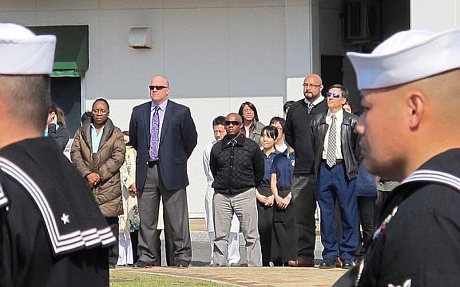 A crowd consisting of American and Japanese civilian base employees gathered across the street as sailors from Sasebo Naval Base bowed their heads in silence for victims of the March 11, 2011 earthquake and tsunami on the afternoon of March 11, 2013.