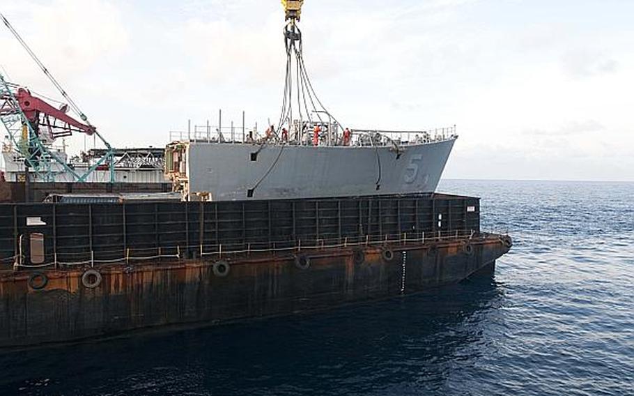 The contracted crane vessel M/V Jascon 25 on March 26, 2013, removes the bow of the mine countermeasure ship USS Guardian, which ran aground on the Tubbataha Reef on Jan. 17, 2013, and places it onto the barge Seabridge. The U.S. Navy and contracted salvage teams continue damage assessments and the removal of equipment and parts to prepare the grounded ship to be safely dismantled and removed from Tubbataha Reef.