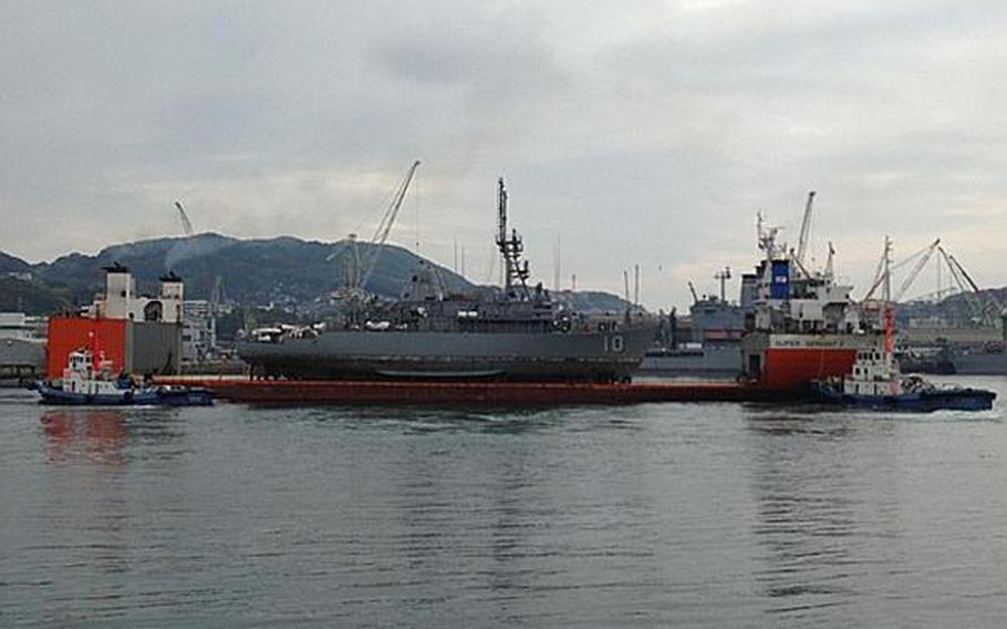 The USS Warrior arrives in Sasebo atop a heavy-lift vessel on March 27, 2013.