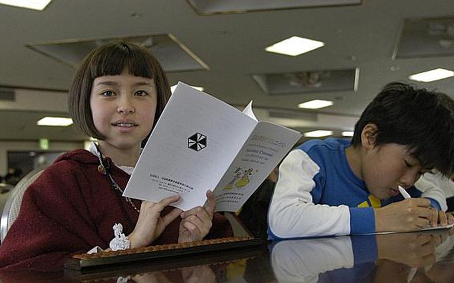 Klara Enriquez, a fourth-grader at Shirley Lanham Elementary School, takes a quick break from reading the program for the March 28, 2013, soroban event where American students and Japanese students showed off their abilities to manually computer complex series of numbers.