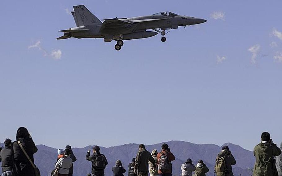 A group of approximately 30 aircraft enthusiasts nicknamed "tailwatchers" photograph an F/A-18 Hornet outside Naval Air Facility, Atsugi, Japan on Nov. 27, 2012.
