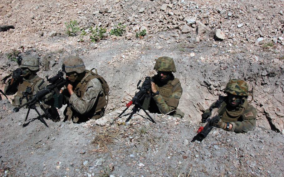 U.S. Marines and Australian soldiers take cover in a trench during an exercise at Mount Bundey Training Area, Northern Territory on Thursday. 

