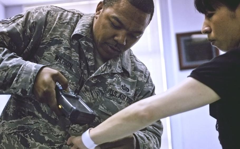 Tech. Sgt. Charles Wilson, a member of the individual personnel readiness section, scans an identification wristband during an exercise at Yokota Air Base, Japan, July 15, 2013.

Eric Guzman/Stars and Stripes