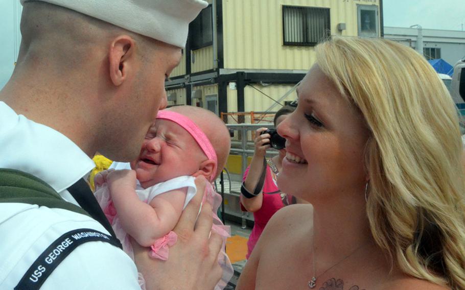 Petty Officer 2nd Class Joshua Dingman greets his wife and meets his 7-week-old daughter, Evelynn, for the first time at Yokosuka Naval Base on Friday. About 5,000 sailors disembarked from the aircraft carrier USS George Washington, which returned to Yokosuka for a break in its ongoing Western Pacific patrol.
Erik Slavin/Stars and Stripes