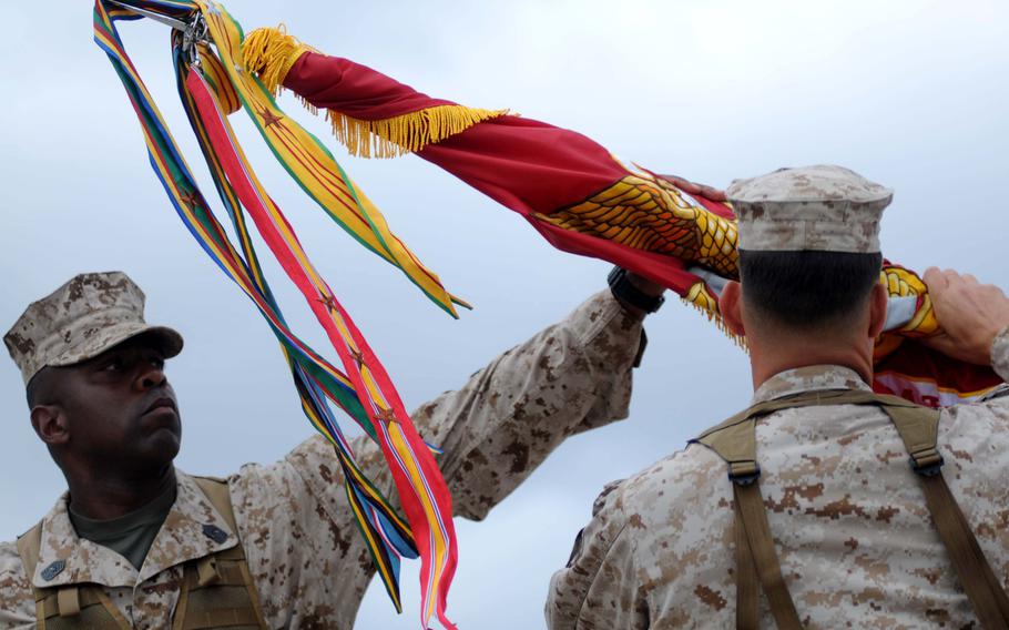 Sgt. Maj. Devon Lee, the sergeant major of Marine Medium Tiltrotor Squadron 262, helps unveil the squadron's new battle colors in a ceremony aboard Marine Corps Air Station Futenma, Okinawa, Aug. 30, 2013.