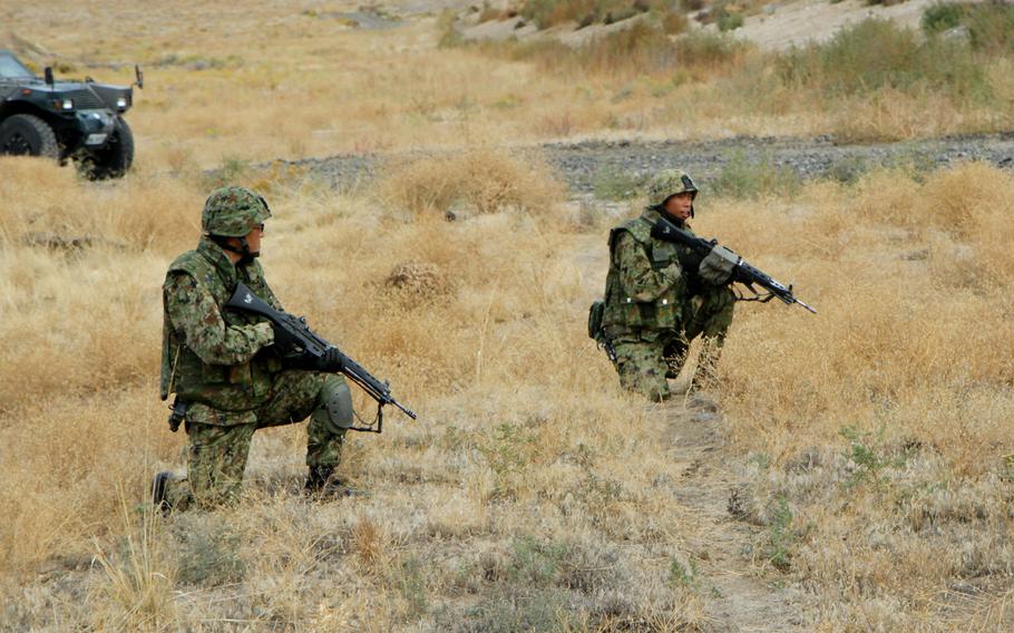 In this file photo from Sept. 17, 2103, Japanese Ground Self-Defense Force soldiers kneel as they wait for movement orders during a platoon live-fire training exercise at Yakima Training Center, Wash. The joint U.S.-Japanese exercise was part of Operation Rising Thunder.