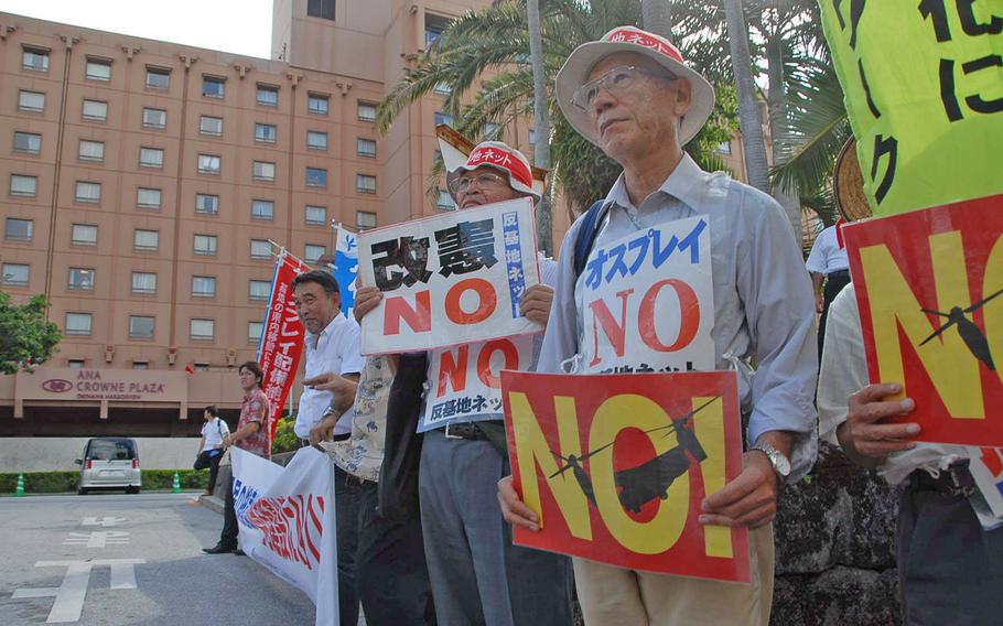 Okinawans opposed to the U.S. military picket Oct. 8 outside a hotel where the prefecture's governor and ministers from Tokyo met to discuss the relocation of Marine Corps Air Station Futenma.