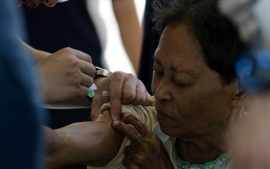 A volunteer health care provider immunizes a Super Typhoon Haiyan victim on November 15, 2013.