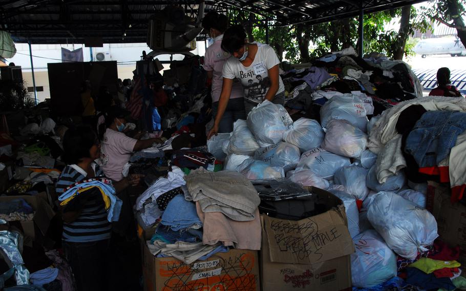 Volunteers at Villamor Air Base in Manila separate piles of donated clothing that will be given to Typhoon Haiyan evacuees from Tacloban and the surrounding areas. The U.S. military has flown nearly 11,600 evacuees to Villamor since the storm hit earlier this month.