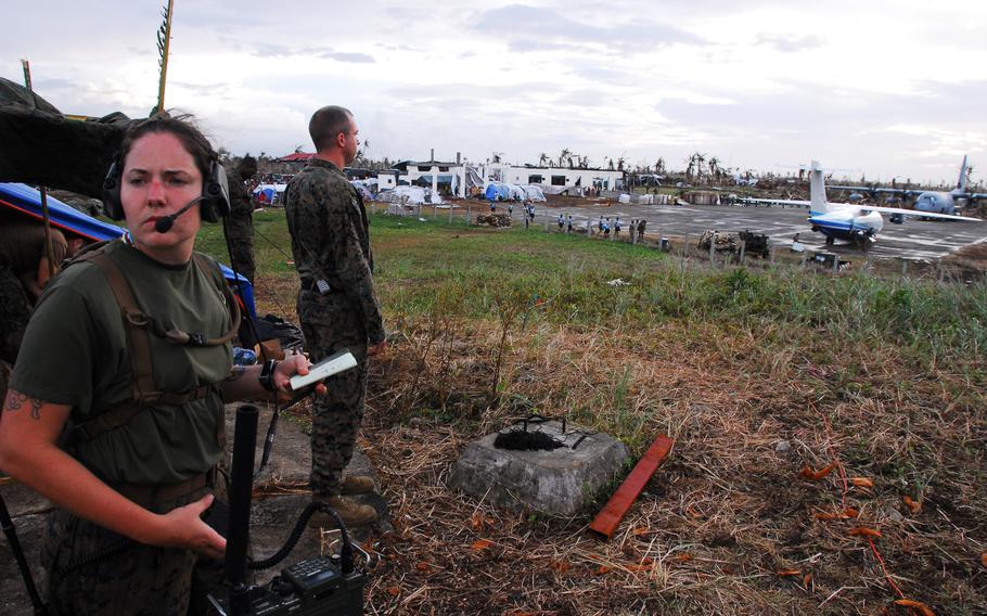 Marine Cpl. Eden Dillon, left, controls aircraft at Guiuan Airport while Staff Sgt. Justin Kroemer keeps watch Nov. 21, 2013.  After more than a week on the ground helping Typhoon Haiyan victims, the Marines are packing up and heading back to Okinawa.