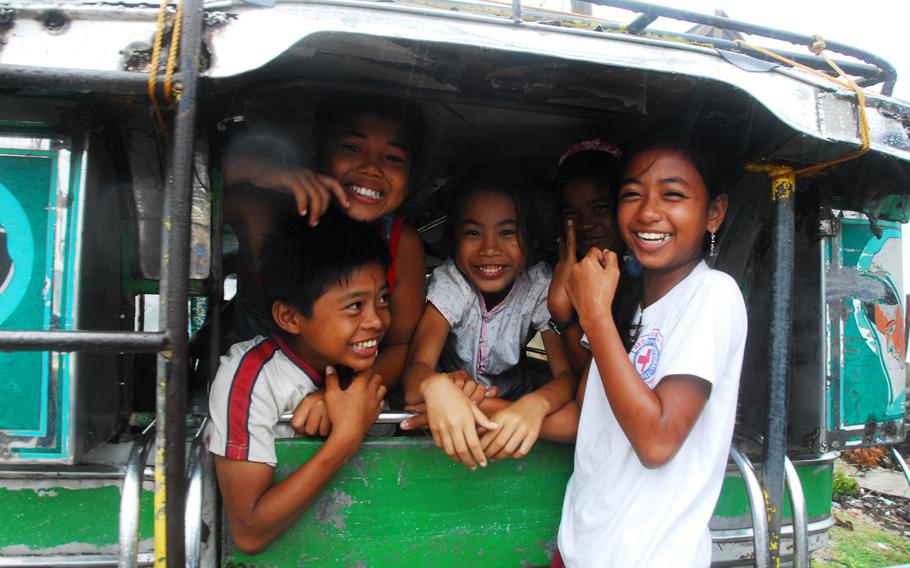 Children shelter from rain inside a Jeepney in Guiuan last Friday. Officials there say locals are resilient despite the fact that most of their homes were destroyed or damaged by Typhoon Haiyan.