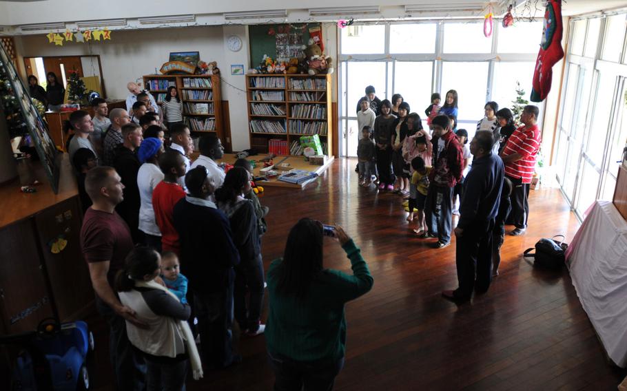 Marines and family members of 3rd Intelligence Battalion say goodbye to the children of the Nagomi Nursing Home for Children, after delivering dozens of gifts to the facility in Kin, Okinawa, Dec. 23, 2013. 

Lisa Tourtelot/Stars and Stripes