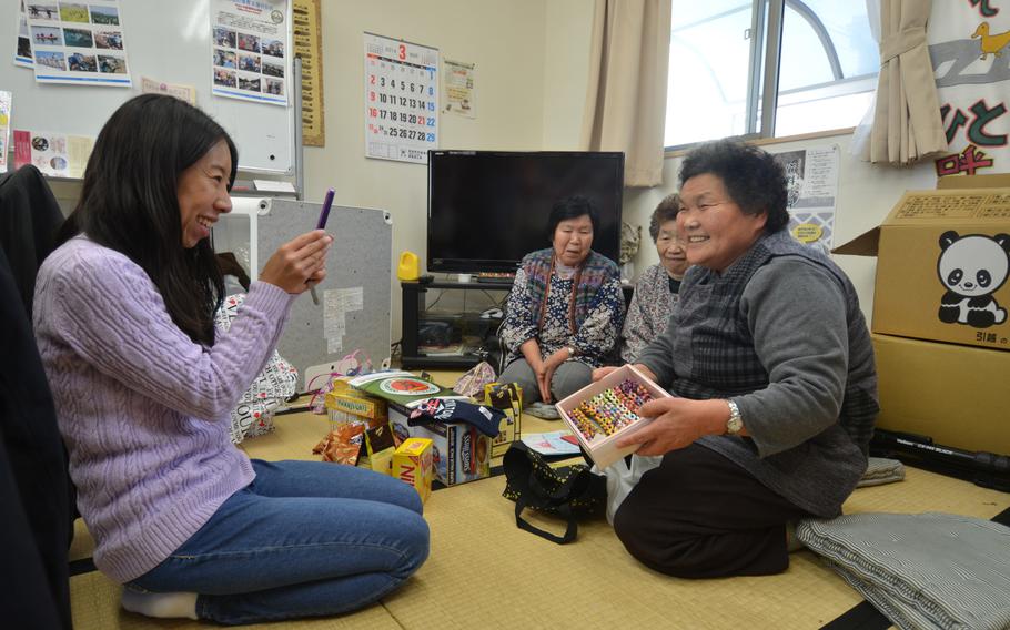 Navy spouse Masako Sullivan, left, shares gifts donated by military families with residents of the Terauchi No. 2 temporary housing complex in Minamisoma, Japan, about 30 minutes west of the Fukushima shore.
