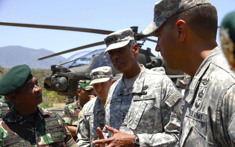 U.S. Army Pacific commander Gen. Vincent Brooks talks to Indonesian army officers about Apache attack helicopters during a tour of Garuda Shield exercise equipment on Sept. 24, 2014, on Java Island. In the background is one of four Apaches brought to Indonesia for the exercise, which is the first leg of Pacific Pathways.