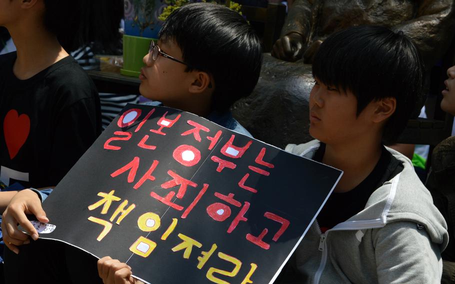 Korean children hold a sign during a protest across the street from the Japanese Embassy in Seoul, South Korea, on May 21, 2014. A protest is held every Wednesday over the issue of Korean women forced into sexual slavery by Japan during World War II.