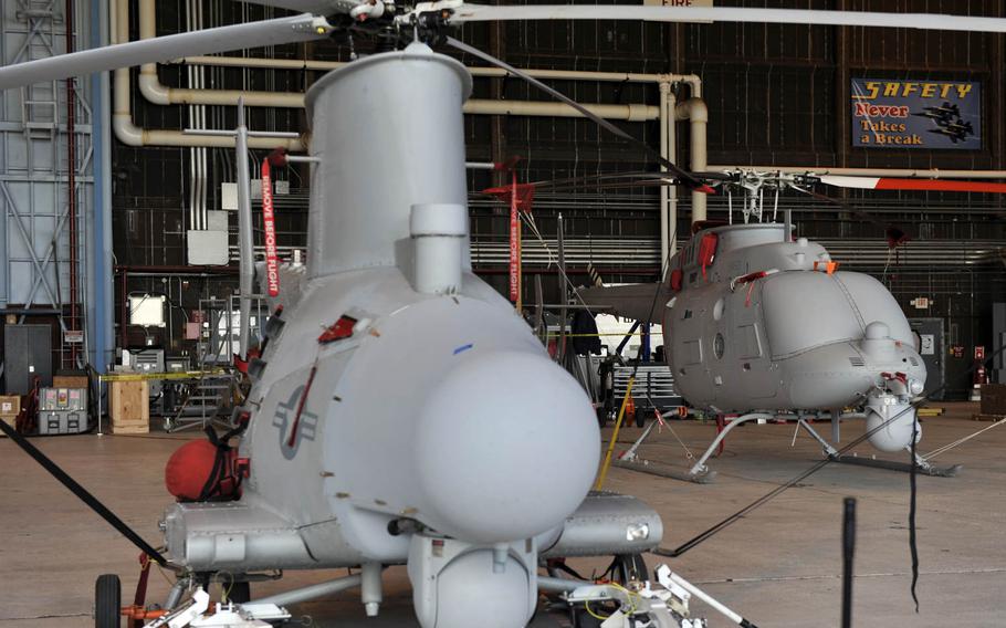 The MQ-8B, left, and larger MQ-8C Fire Scout helicopters.