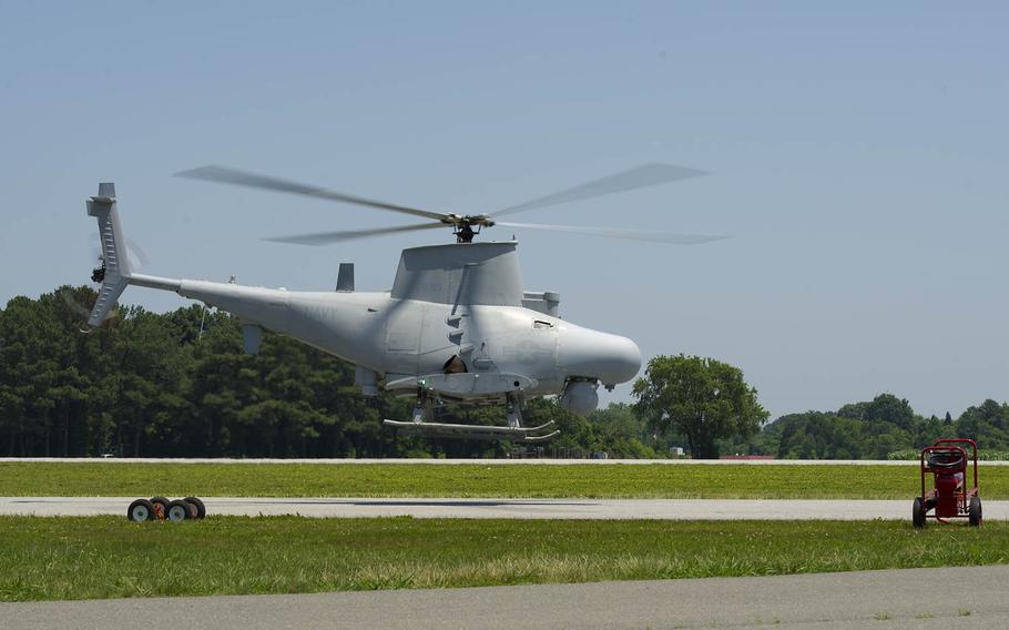 A Fire Scout unmanned helicopter hovers over a landing zone.
