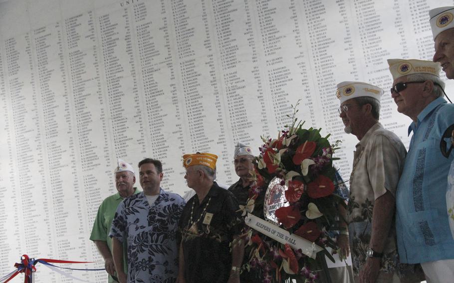 Members of AMVET pose in front of the memorial wall on Nov. 11, 2014, in the USS Arizona Memorial Shrine Room in Honolulu after a dedication of the wall, for which AMVET spear-headed fundraising.