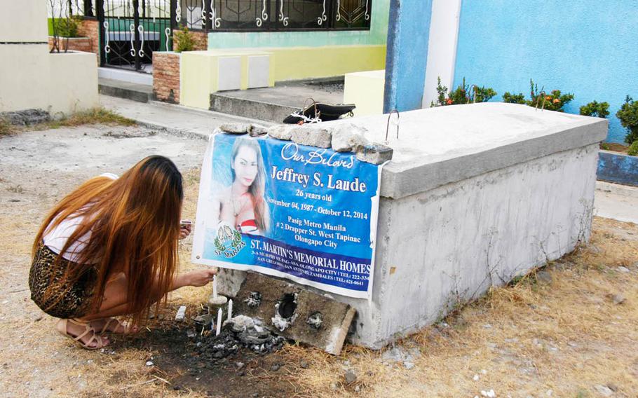 A Filipina transgender woman who shared an apartment with Jennifer Laude lights candles at her late friend's tomb at a cemetery in Olongapo, Philippines, in March 2015. Laude was found dead in an Olongapo hotel Oct. 11, 2014, after checking into a local hotel with a U.S. Marine, authorities say.