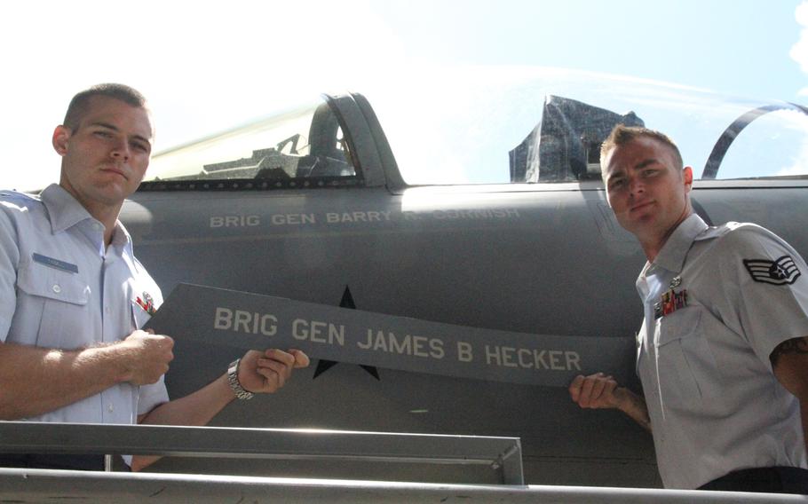Senior Airman Clay Tindell, left, and Staff Sgt. Brad Prohaska symbolically remove the name plate of Brig. Gen. James Hecker from his jet, revealing the name of incoming 18th Wing commander Brig. Gen. Barry Cornish. Cornish replaced Hecker on Thursday at a change-of-command ceremony at Kadena Air Base, Okinawa.