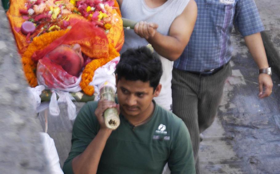 Family members carry the body of a deceased relative to the bank of the Bagmati River, Nepal, on May 6, 2015.