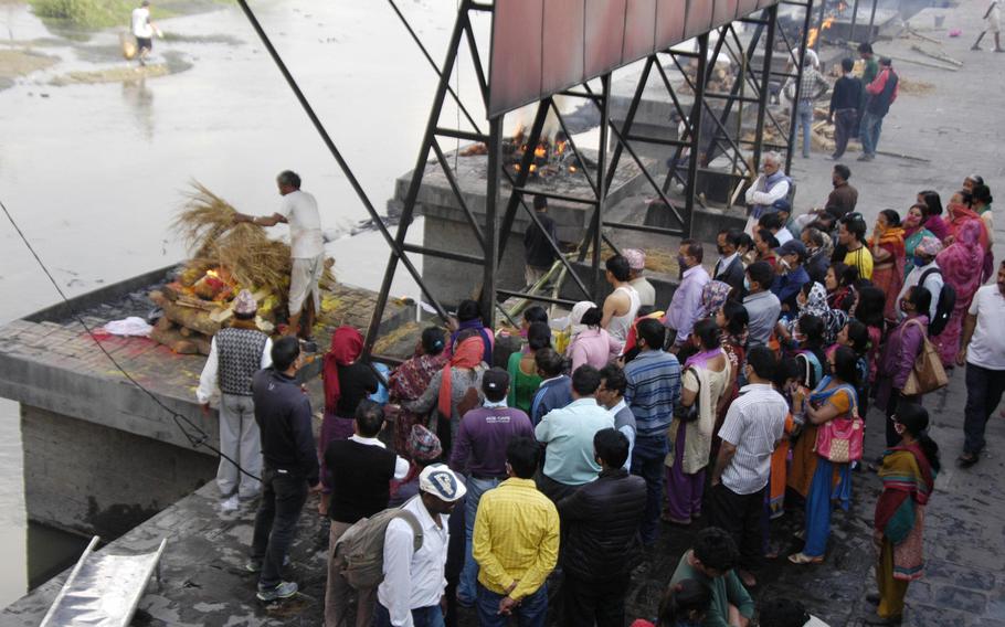 Family and friends gather while the body of a recently deceased man is burned beside the Bagmati River, Nepal. Each day since the devastating earthquake hit the region, families have been making the trip to the river to pay their last respects to loved ones.